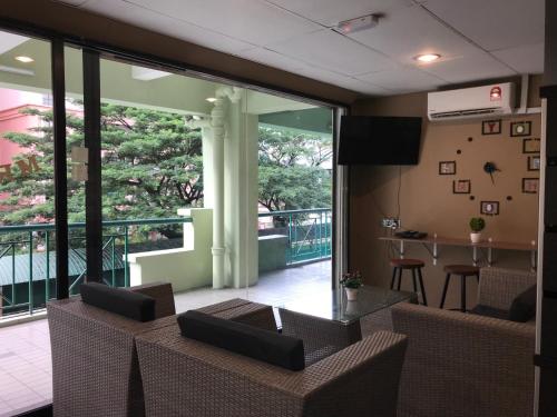 a lobby with chairs and a table and a balcony at Nusantara Mattwaddien Hostel in Kota Kinabalu