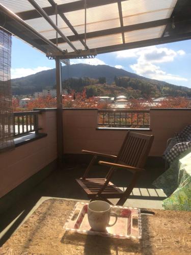 a chair on a balcony with a coffee cup on a table at 民宿とまとハウスTomato House in Funehiki