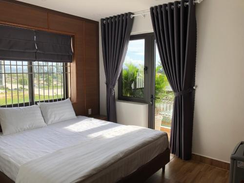 - une chambre avec un lit et une grande fenêtre dans l'établissement HOÀNG SA HOTEL, à Cam Ranh
