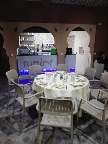 a dining room with a table and chairs and a kitchen at DAR AMGHAR in Tafraoute