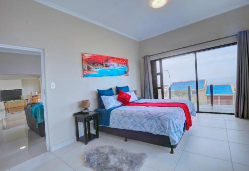 a bedroom with a bed with a view of the ocean at JoJo's BnB in Mossel Bay