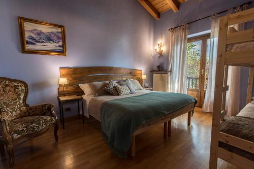 um quarto com uma cama, uma cadeira e uma janela em Le Jasmin em Aosta