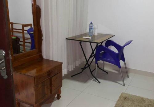a table with chairs and a table with a bottle of water on it at Himo Guest Inn in Dehiwala
