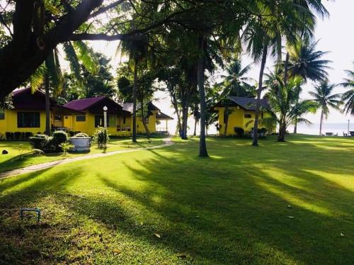 una casa con un patio con palmeras en Malai-Asia Resort, en Thap Sakae