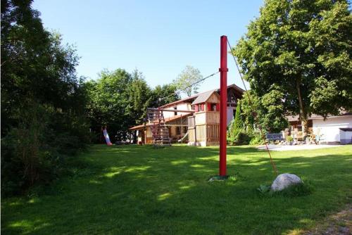 a red pole in the grass in front of a house at Ferienhof Musch GbR in Rot an der Rot
