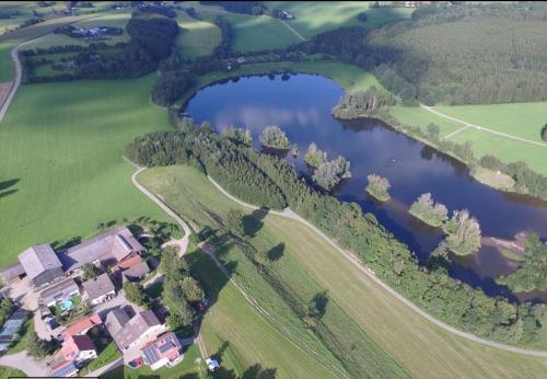 an aerial view of a house and a lake at Ferienhof Musch GbR in Rot an der Rot