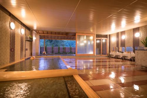 a large swimming pool in a building at Hotel Hanamaki in Hanamaki