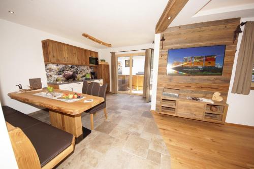 eine Küche und ein Esszimmer mit einer Holzwand in der Unterkunft Kaiserappartements-Marie in Ellmau