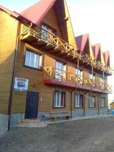 a large wooden building with a balcony on it at Dream House in Yablunytsya