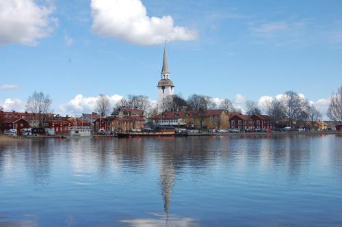 a view of a lake with a church in the background at Röda Magasinet in Mariefred