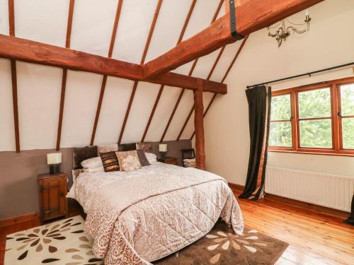 1 dormitorio con 1 cama en una habitación con vigas de madera en Derrywater House, en Aughrim
