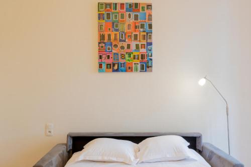 un lit avec deux oreillers et un tableau au mur dans l'établissement Le Bord de Garonne, à Toulouse