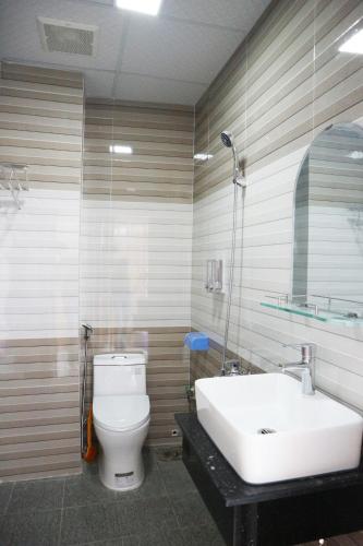 a bathroom with a white toilet and a sink at Anh Quân Hotel in Quy Nhon