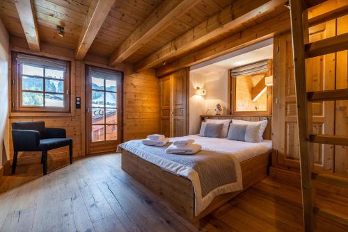 une chambre avec un lit dans une pièce aux murs en bois dans l'établissement Abachi Chalet Les Gets - by EMERALD STAY, aux Gets