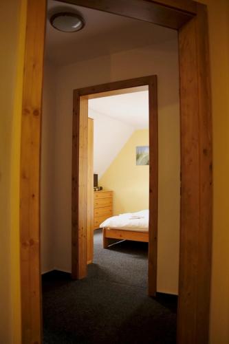 a bedroom with a door leading to a bed at Penzion U Studeného potoka in Nové Hutě