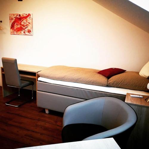 a bedroom with a bed and a desk and a chair at Hotel Stegmann's Hof in Sehnde
