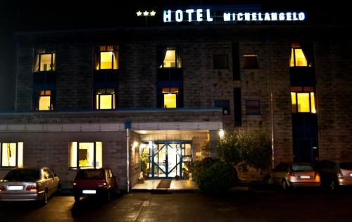 un hotel con coches aparcados fuera de él por la noche en Hotel Michelangelo, en Rezzato