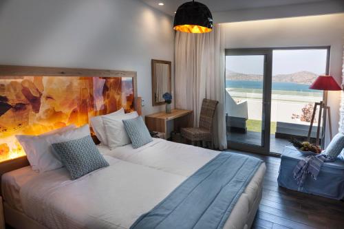 a bedroom with a large bed with a view of the ocean at Elounda Orama in Elounda