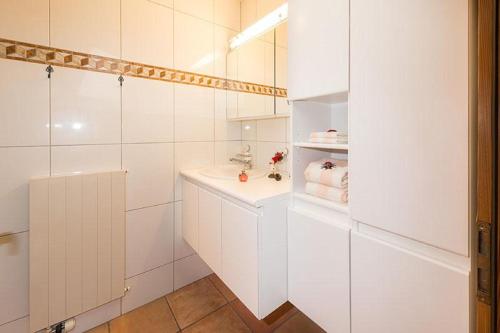 een witte badkamer met een wastafel en een spiegel bij Försterli West in Grächen