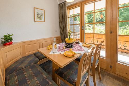 une salle à manger avec une table et des chaises en bois dans l'établissement Försterli West, à Grächen