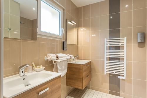 a bathroom with a sink and a mirror at Hotel Restaurant LE YETI in Les Rousses