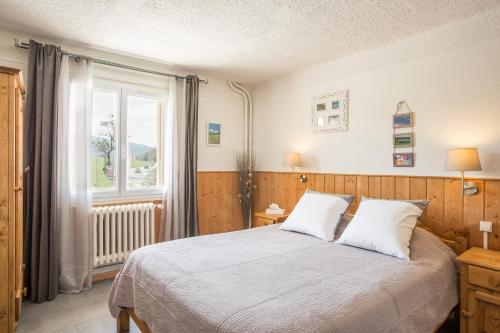 a bedroom with a large bed and a window at Hotel Restaurant LE YETI in Les Rousses