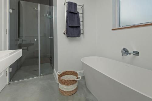 ein Bad mit einer Badewanne, einem Waschbecken und einer Dusche in der Unterkunft Perla in Hermanus