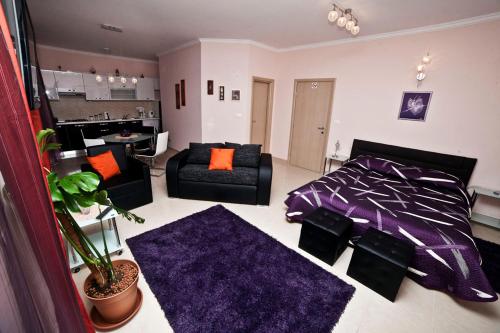 ein Wohnzimmer mit einem lila Bett und einem Sofa in der Unterkunft Split Apartments Peric in Split