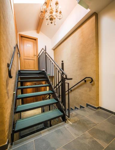 a staircase in a building with a chandelier at Auberge Du Relais Postal in Asselborn