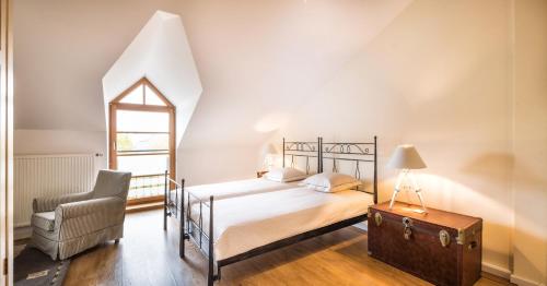 a bedroom with a bed and a chair at Auberge Du Relais Postal in Asselborn