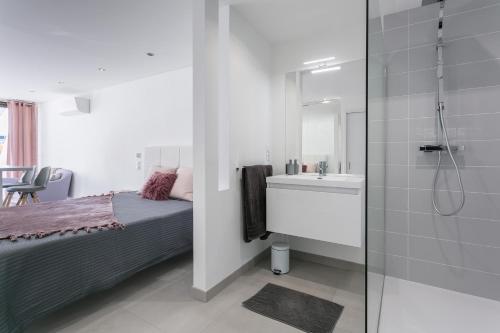 une chambre avec un lit et une salle de bain avec douche dans l'établissement Cap d'Agde Naturiste, au Cap d'Agde