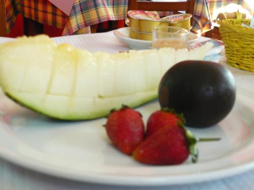 a plate of fruit with strawberries and a banana at Hotel Rural Suquin in Navia
