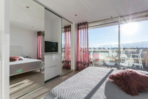 um quarto com uma cama, uma televisão e uma varanda em Cap d'Agde Naturiste em Cap d'Agde