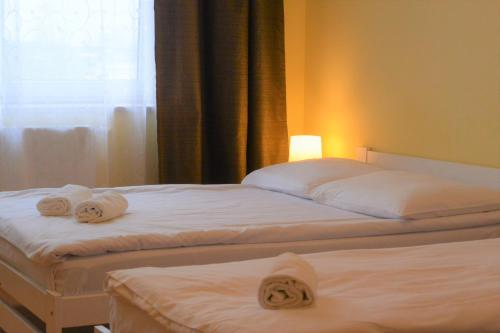 two beds in a hotel room with towels on them at Hostel DV Morski - z prywatnymi łazienkami in Gdynia