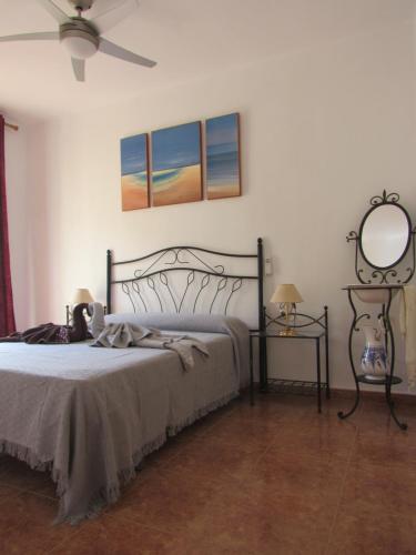 een slaapkamer met een bed, een spiegel en een ventilator bij Apartamento Playa Malvarrosa, Valencia in Valencia