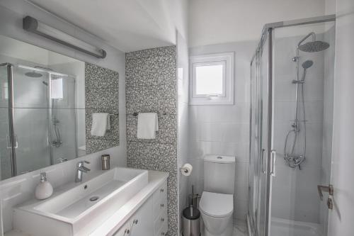 a white bathroom with a sink and a toilet at Konnos Hight Villa in Protaras