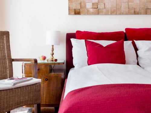 a bedroom with a bed with red and white pillows at Boutiquehotel Stadthalle in Vienna