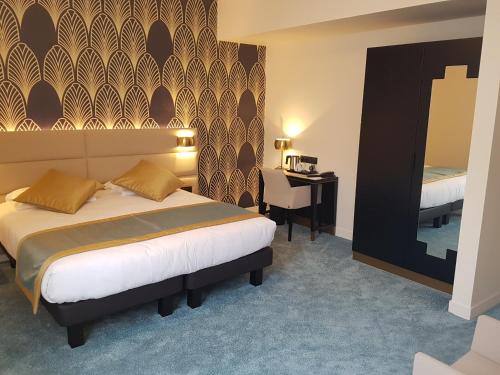 a bedroom with a bed and a desk in a room at Best Western Hôtel Journel Paris Sud in Ris-Orangis