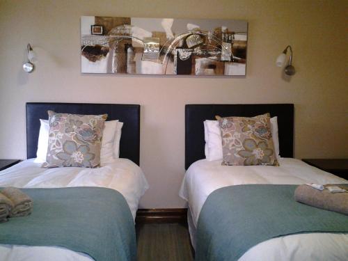 two beds with pillows in a room at Jock of the Bushveld in Barberton