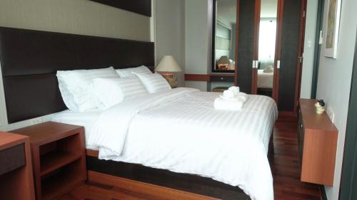 a bedroom with a large bed with white sheets at Today Tonight in Bangkok