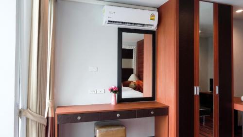 a mirror on a wooden shelf in a room at Today Tonight in Bangkok