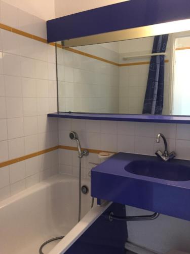 La salle de bains est pourvue d'un lavabo bleu et d'une baignoire. dans l'établissement Appartement à Cap Estérel Village Pierre et Vacances Quartier Belvédère Piscines et parking inclus, à Agay