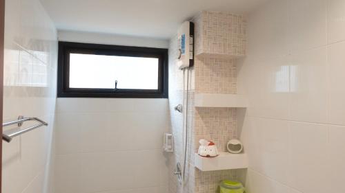 a white bathroom with a shower and a window at Today Tonight in Bangkok