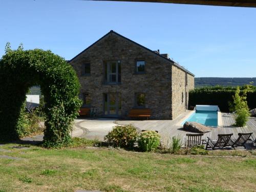una vieja casa de piedra con una piscina frente a ella en Gorgeous holiday home in Stoumont with garden, en Stoumont
