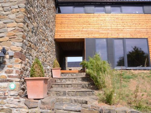 una casa de piedra con escaleras que conducen a un edificio en Gorgeous holiday home in Stoumont with garden, en Stoumont