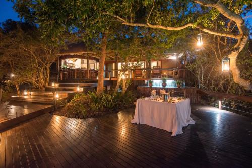 a table on a deck at night with lights at Waterbuck Game Lodge Thornybush Nature Reserve in Thornybush Game Reserve