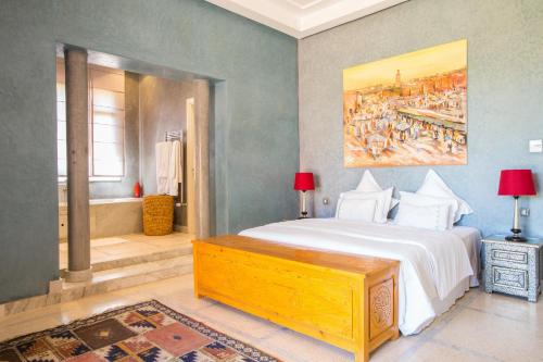 a bedroom with a bed and a painting on the wall at Villa Koutoubia, jardin luxuriant, piscine et spa in Marrakech
