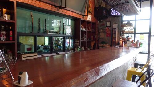 a bar with a wooden counter in a room at Today Tonight in Bangkok