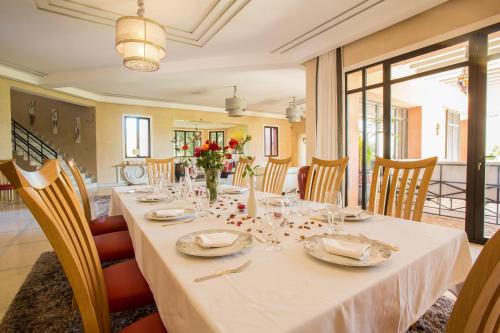 a dining room with a long table with flowers on it at Villa Koutoubia, jardin luxuriant, piscine et spa in Marrakech