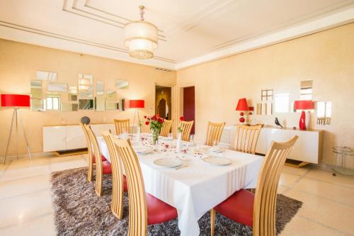 a dining room with a white table and chairs at Villa Koutoubia, jardin luxuriant, piscine et spa in Marrakech